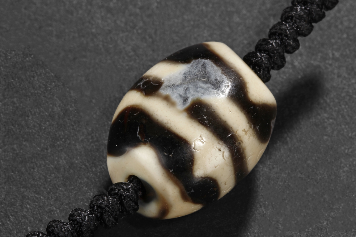 A PAIR OF ARCHAIC 'TIGER TEETH' TIBETAN DZI BEADS