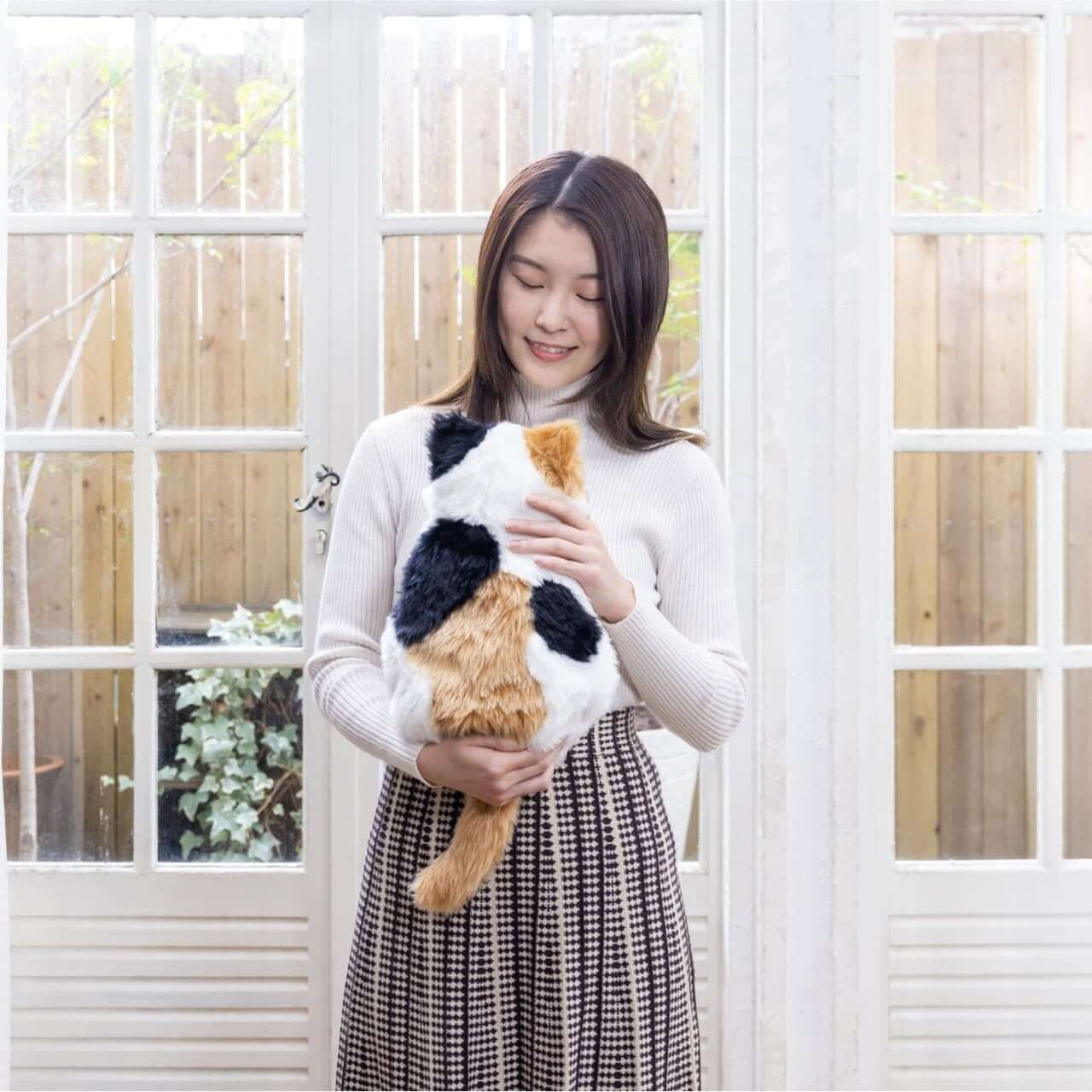 撫でるとゴロゴロ音が聞こえる猫型クッション『MeowEver』から三毛猫