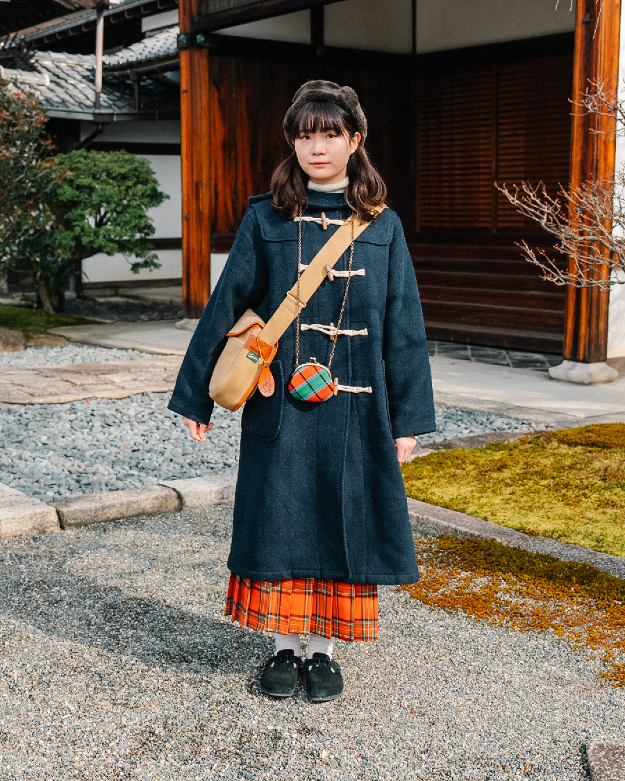 ダッフルコートの丈からちらりと覗くスカートとがま口ポーチのチェック