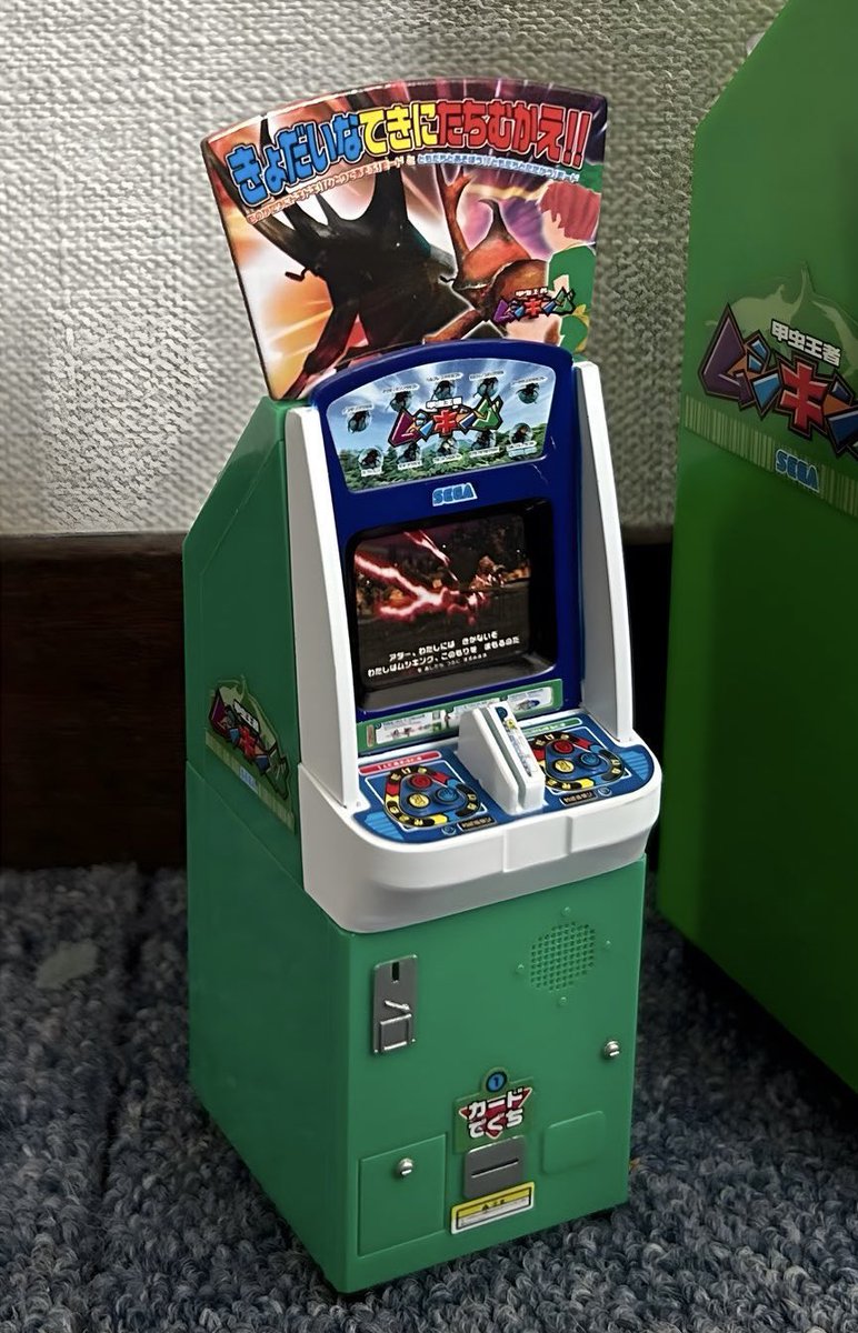 甲虫王者ムシキングの筐体の上部に告知のポップが大きく付いています